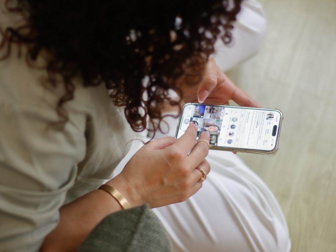 Mãos mexendo num perfil do Instagram no celular
