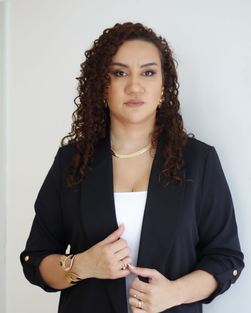 Joyce Leão de blazer preto, olhando para a câmera